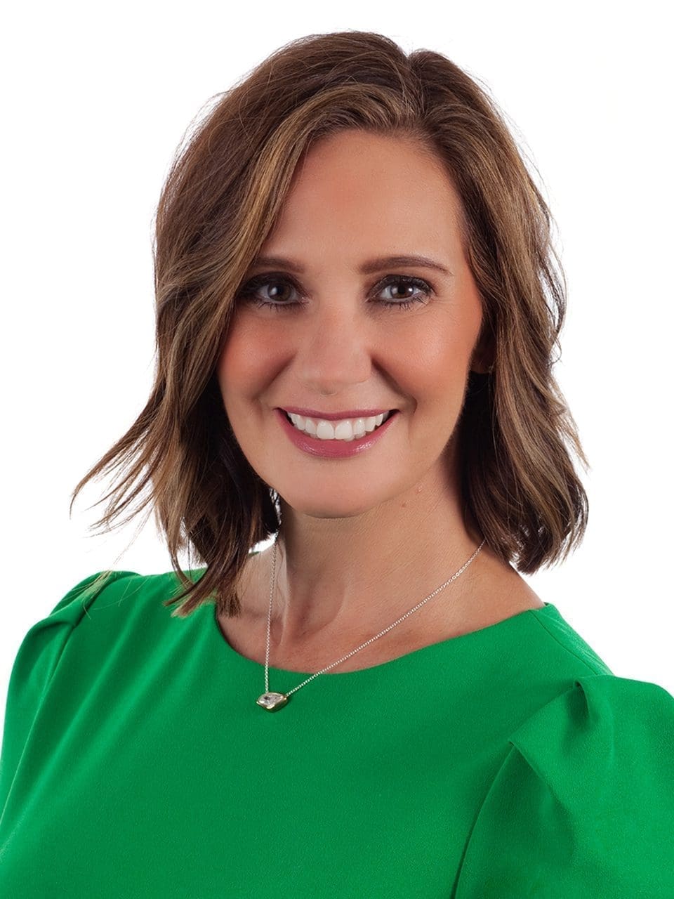 Image of a woman smiling with a bright green dress.